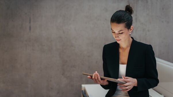 Eine Frau ist bei der Arbeit und nutzt ein Tablet.